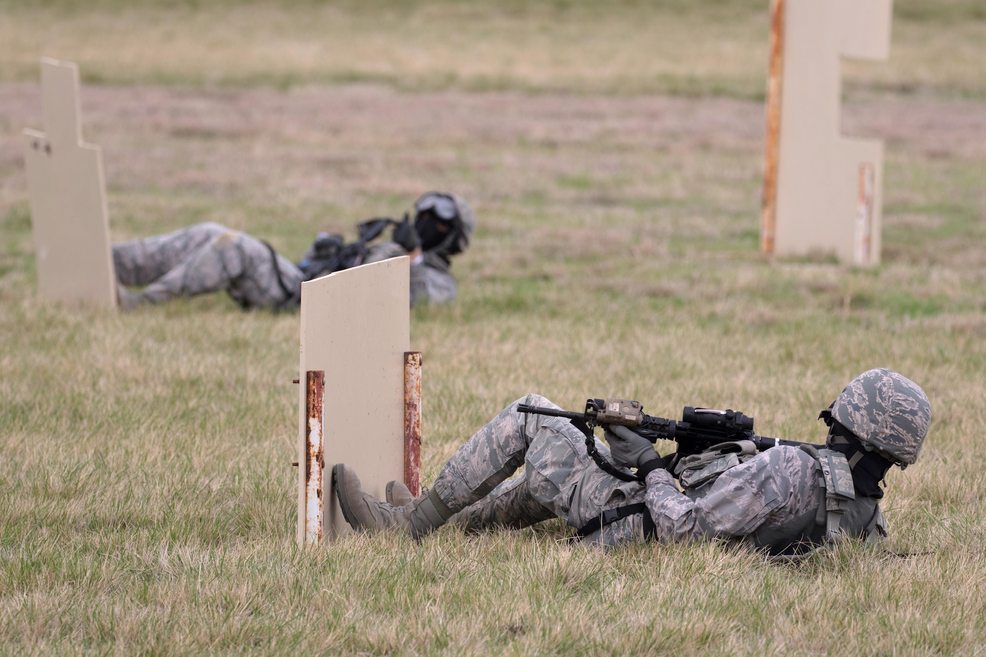U.S. Air Force Staff Sgt. Jose Salinas, left, 7th Security Forces Squadron evaluator, and Airman 1st Class Ruben Uquillas, 7th SFS member, communicate during a shoot, move and communicate challenge March, 11, 2017, at Dyess Air Force Base, Texas. The shoot, move and communicate forces participants to talk, shoot and move between covers while being minimally exposed to enemy actions. (U.S. Air Force Photo by Tricia Bruton)