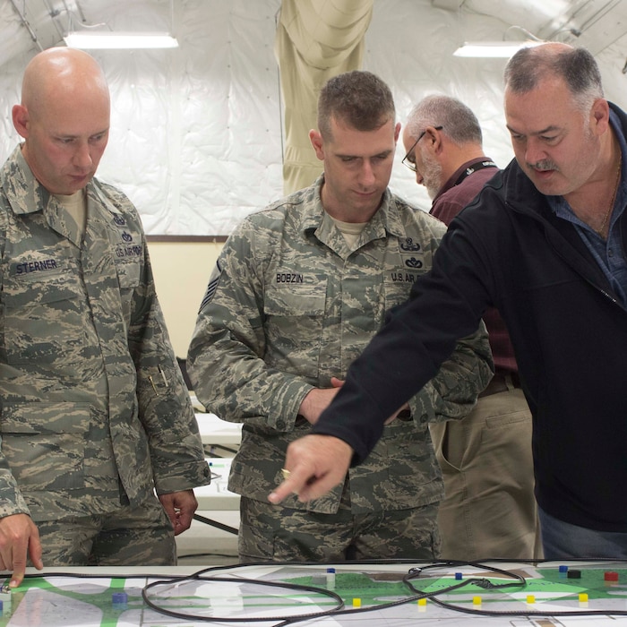 From left, Master Sgt. Ryan Bobzin, Chief Master Sgt. Timothy Sterner and John Olive, Air Force Civil Engineer Center explosive ordnance disposal subject matter expert, focus on making theoretical decisions during a Rapid Airfield Damage Repair, RADR, table top exercise held at Silver Flag exercise site, Tyndall Air Force Base, Florida. The exercise was designed to evaluate the access, mitigate and repair capabilities of the RADR process.  (U.S. Air Force photo/Mekka Parish)