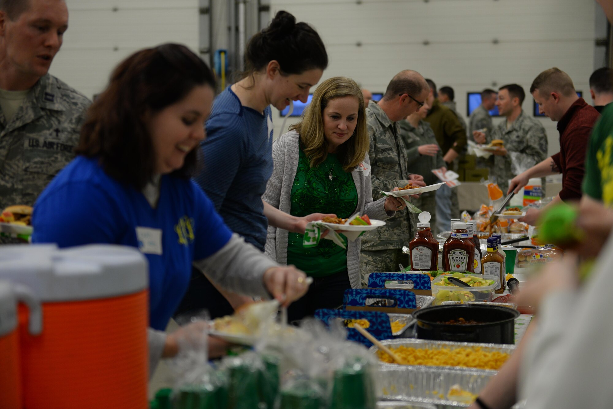 Members of Team Mildenhall prepare their plates during Hearts Apart March 16, 2017, at the fire department on RAF Mildenhall, England. This month’s theme was based on St. Patrick’s Day. Participants enjoyed free food, a bouncy castle, photos with a “Leprechaun” and a magic show. (U.S. Air Force photo by Staff Sgt. Micaiah Anthony)