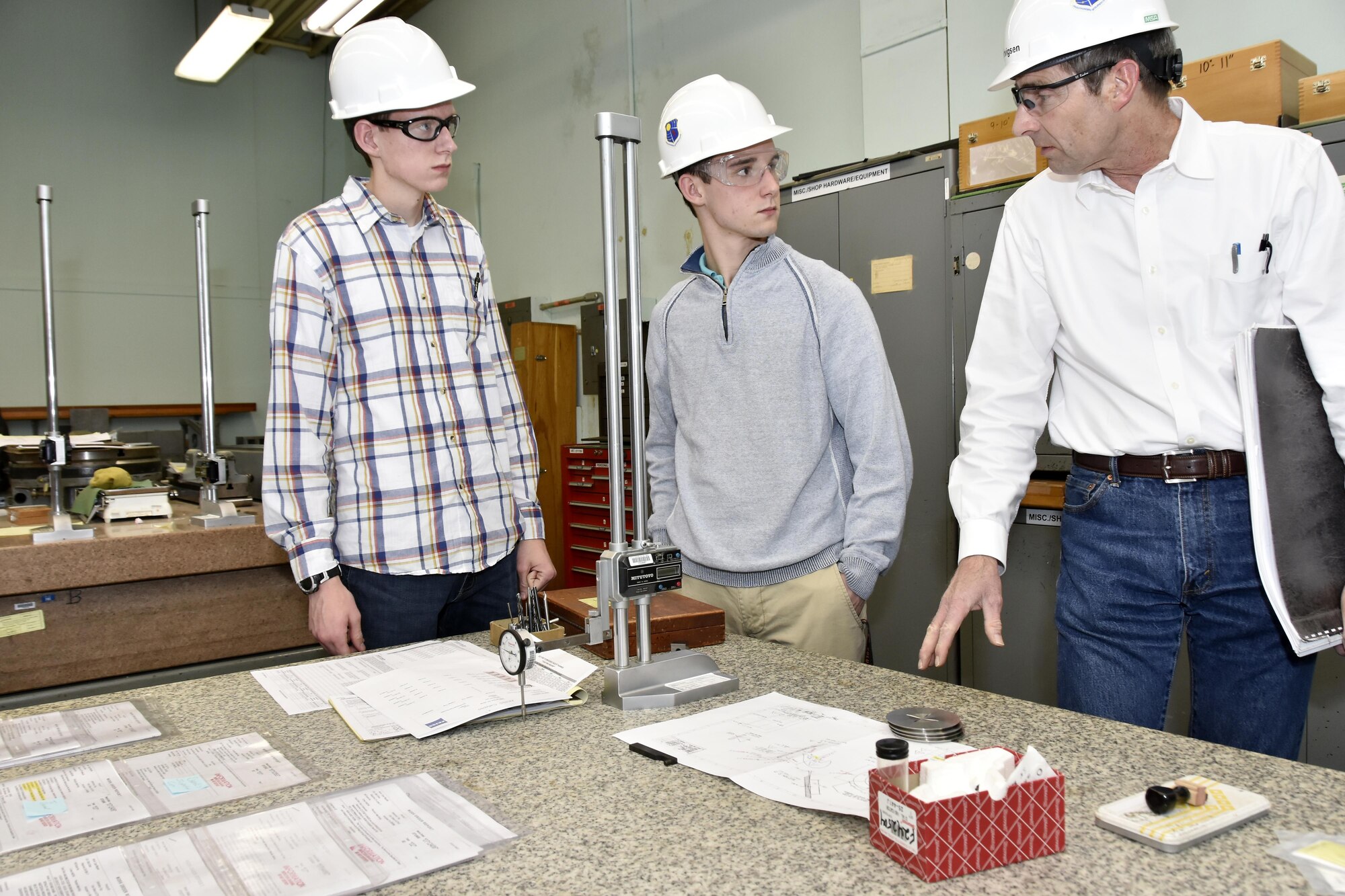 AEDC engineer Tom Hartvigsen, right, discusses AEDC inspection capabilities to prospective engineering students attending Engineers Week Engineer for a Day Feb. 22 at Arnold Air Force Base. Pictured with Hartvigsen is Coffee County Central High School student Andrew Godwin, far left, and Fayetteville High School student Mitchell Beverly. (U.S. Air Force photo/Rick Goodfriend) 