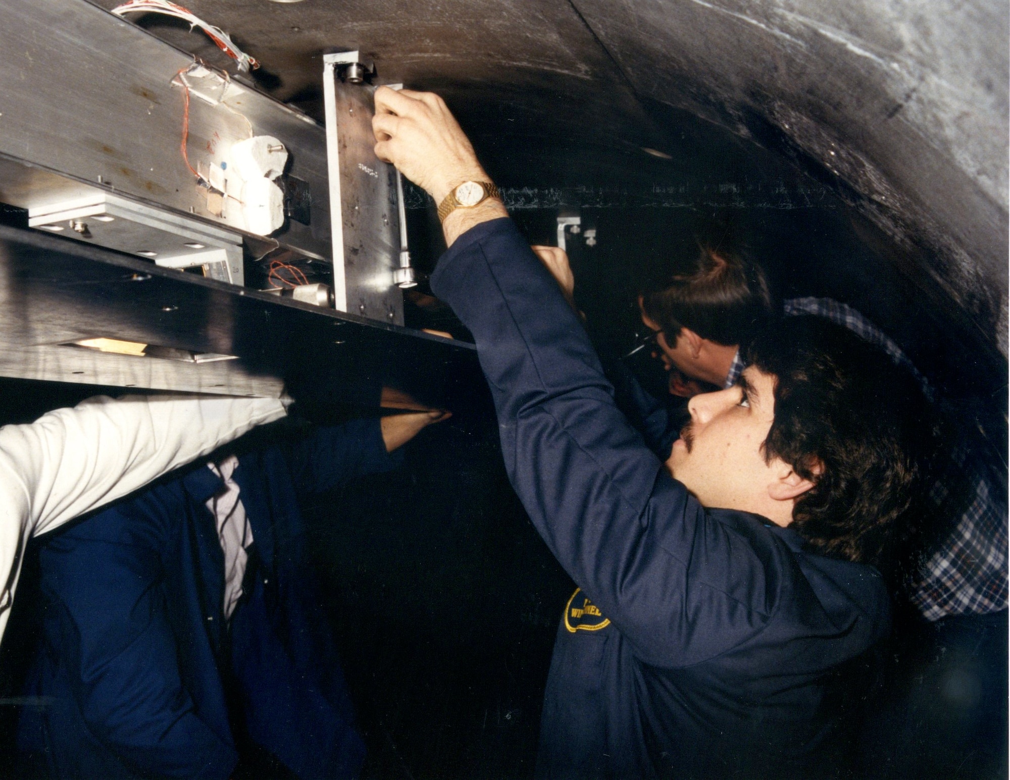 : Dan Marren, front, works as part of a test team on the first aero-optical experiment in the Hypervelocity Wind Tunnel 9, then operated by the Naval Surface Warfare Center, in support of the Strategic Defense Initiative Program in 1984. The innovative test measured precise optical aberrations of target signals presented to interceptor seekers travelling at Mach 10 which enabled the realization of ballistic missile defensive test capabilities used worldwide. Hypervelocity Wind Tunnel 9, located at the Federal Research Center in White Oak, Maryland, is now operated by AEDC. Marren, who is the director of the AEDC White Oak site was recently selected to receive the 2017 American Institute of Aeronautics and Astronautics Ground Testing Technical Committee’s Ground Testing Award. (U.S. Navy photo) 