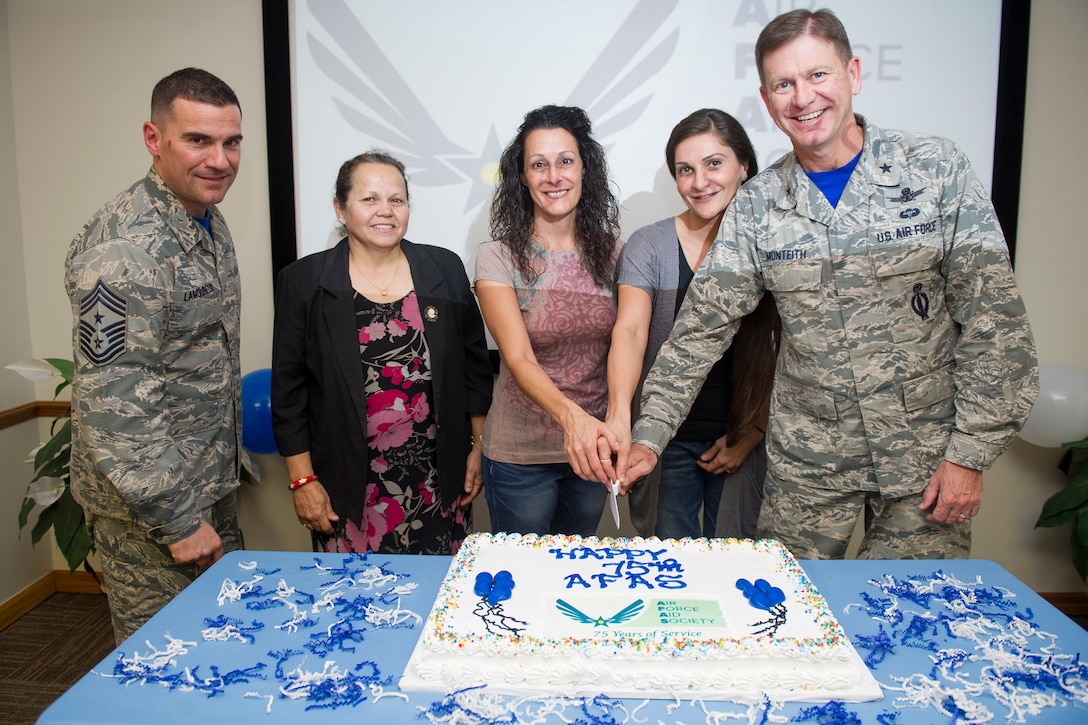 Brig. Gen. Wayne Monteith, 45th Space Wing commander (right), base community members and Chief Master Sgt. Jason Lamoureux, 45th Space Wing command chief, (left), celebrate the 75th anniversary of the Air Force Aid Society during a ceremony March 10, 2017, at Patrick Air Force Base, Fla. The Air Force Aid Society (AFAS) is the official charity of the United States Air Force incorporated in 1942 as a non-profit organization whose mission is to help relieve financial distress of Air Force members and their families and to assist them in financing their higher education goals. (U.S. Air Force photo/Matthew Jurgens) 