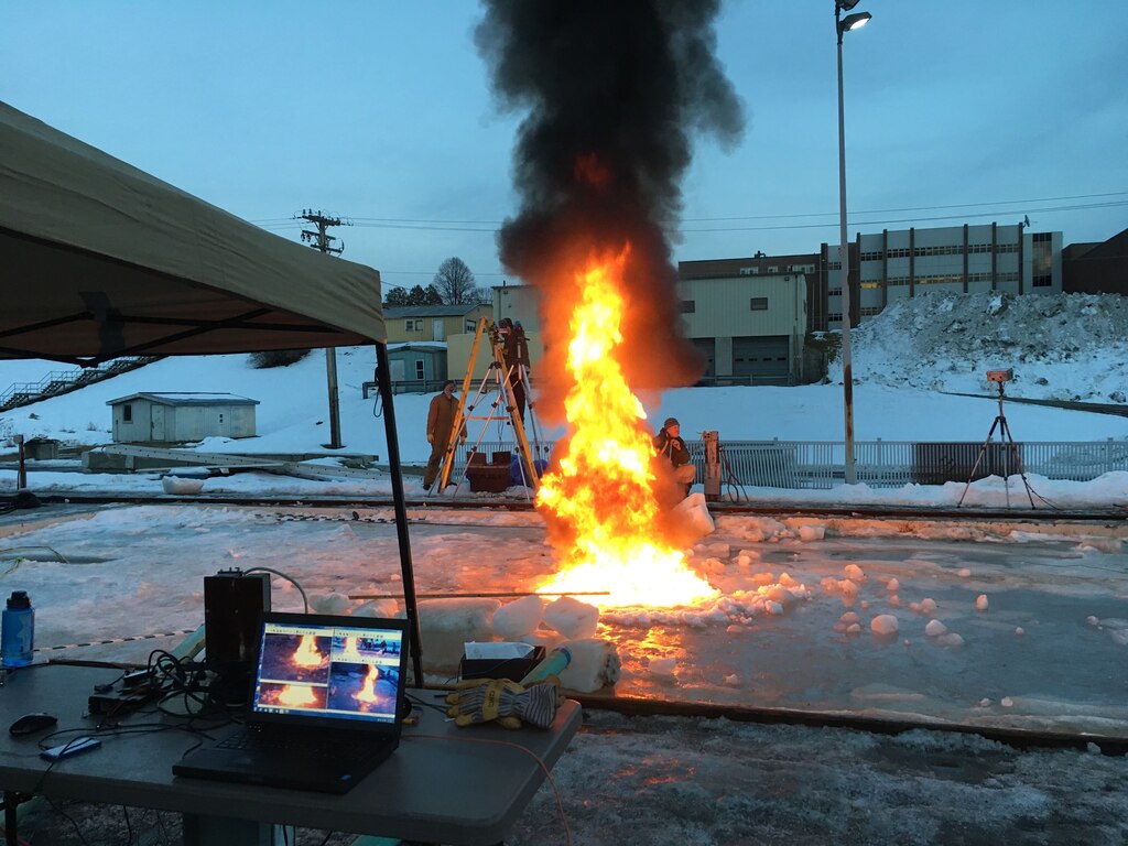 U.S. Army Engineer Research and Development Center’s Cold Regions Research and Engineering Laboratory engineers hosted Applied Research Associates Inc. testing onsite using the Geophysical Research Facility, an outdoor refrigerated basin, to measure burn efficiency of oil in ice. In the foreground a computer screen visually monitors and streams the testing live to sponsors. In the background, researchers use visible and infrared cameras to measure thermal properties.