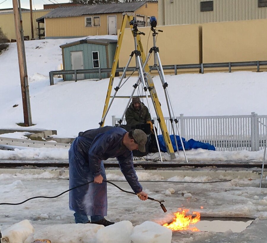 The U.S. Army Engineer Research and Development Center’s Cold Regions Research and Engineering Laboratory recently hosted onsite testing with Applied Research Associates Inc. to measure burn efficiency of oil in ice. CRREL Engineering Technician Bill Burch ignites the oil-laden ice cavity with a propane torch. In the background, thermal imaging cameras are set up to measure the heat of the burn.