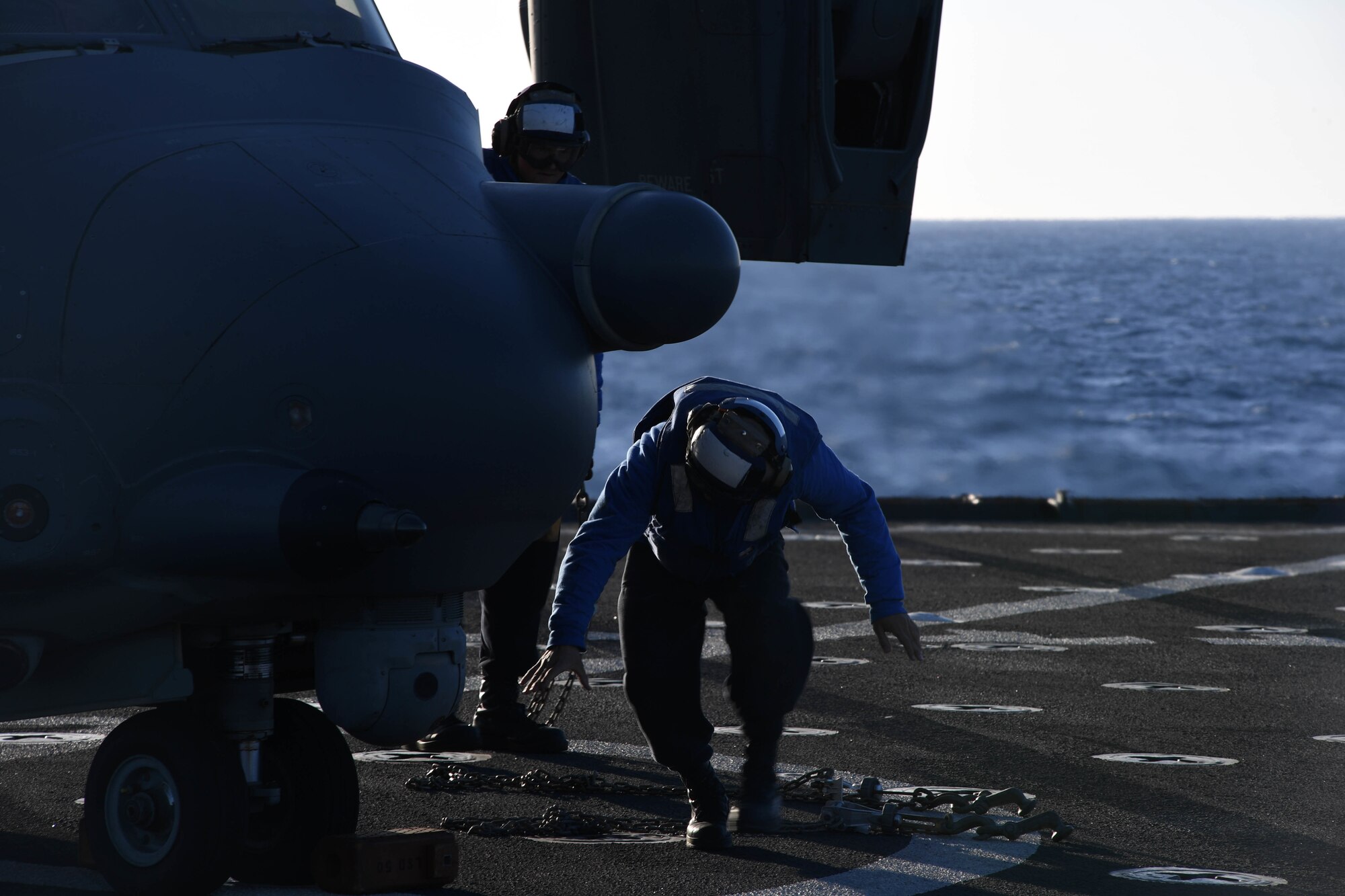 170312-N-ME988-558 MEDITERRANEAN SEA (March 12, 2017) Seaman Jay Lao removes chocks and chains from a CV-22 Osprey assigned to Special Operations Command Europe during deck landing qualifications aboard the amphibious dock landing ship USS Carter Hall (LSD 50), March 12, 2017. The ship is deployed with the Bataan Amphibious Ready Group to support maritime security operations and theater security cooperation efforts in the U.S. 6th Fleet area of operations. (U.S. Navy photo by Mass Communication Specialist 1st Class Darren M. Moore/Released)