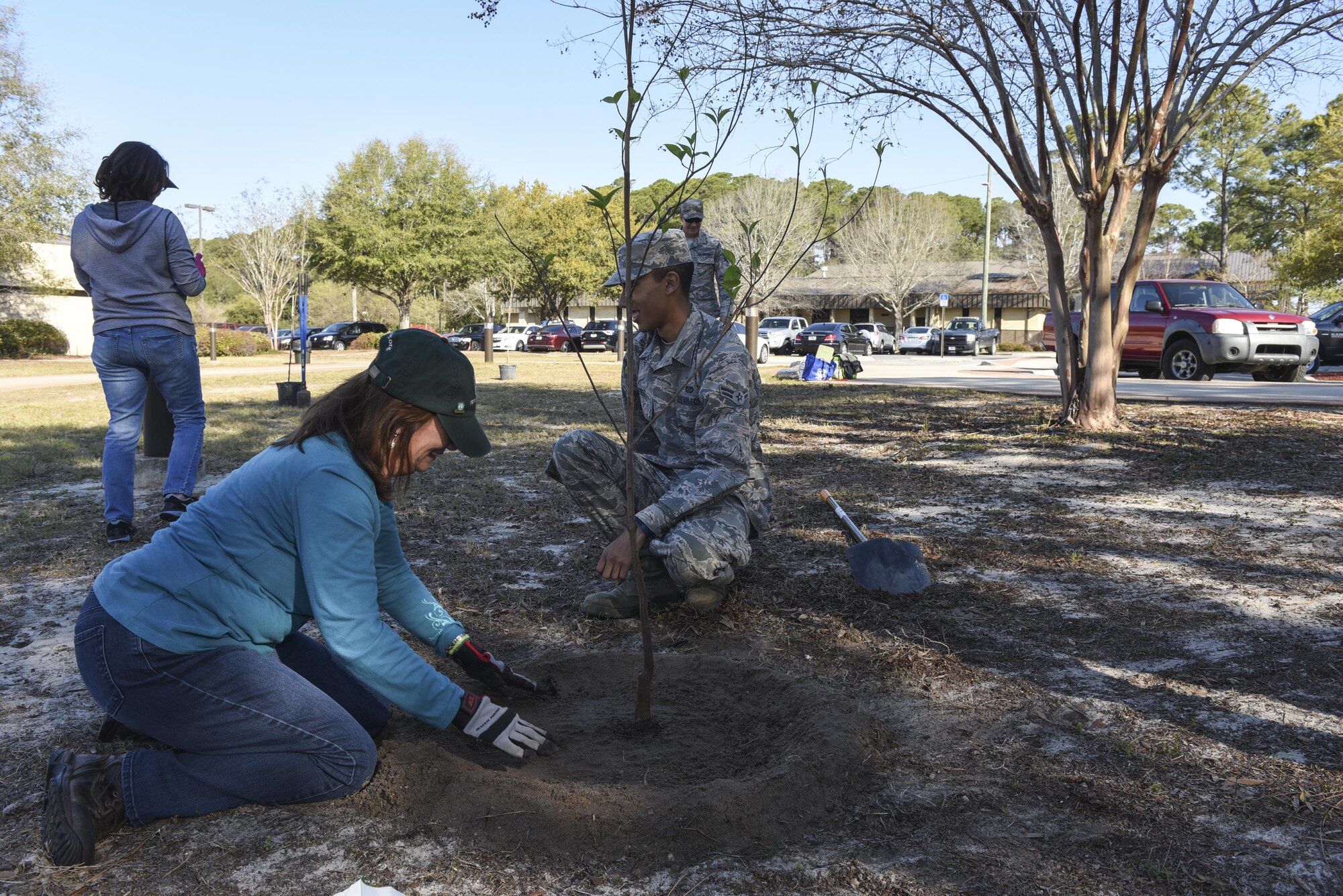 Patricia Williams, the natural and cultural resources program manager with the 1st Special Operations Civil Engineer Squadron, creates a small barrier around the new tree at the community park, Hurlburt Field, Fla., March 17, 2017. The small barrier around the new tree will trap water around the tree to help the tree’s growth. (U.S. Air Force photo by Senior Airman Jeff Parkinson)