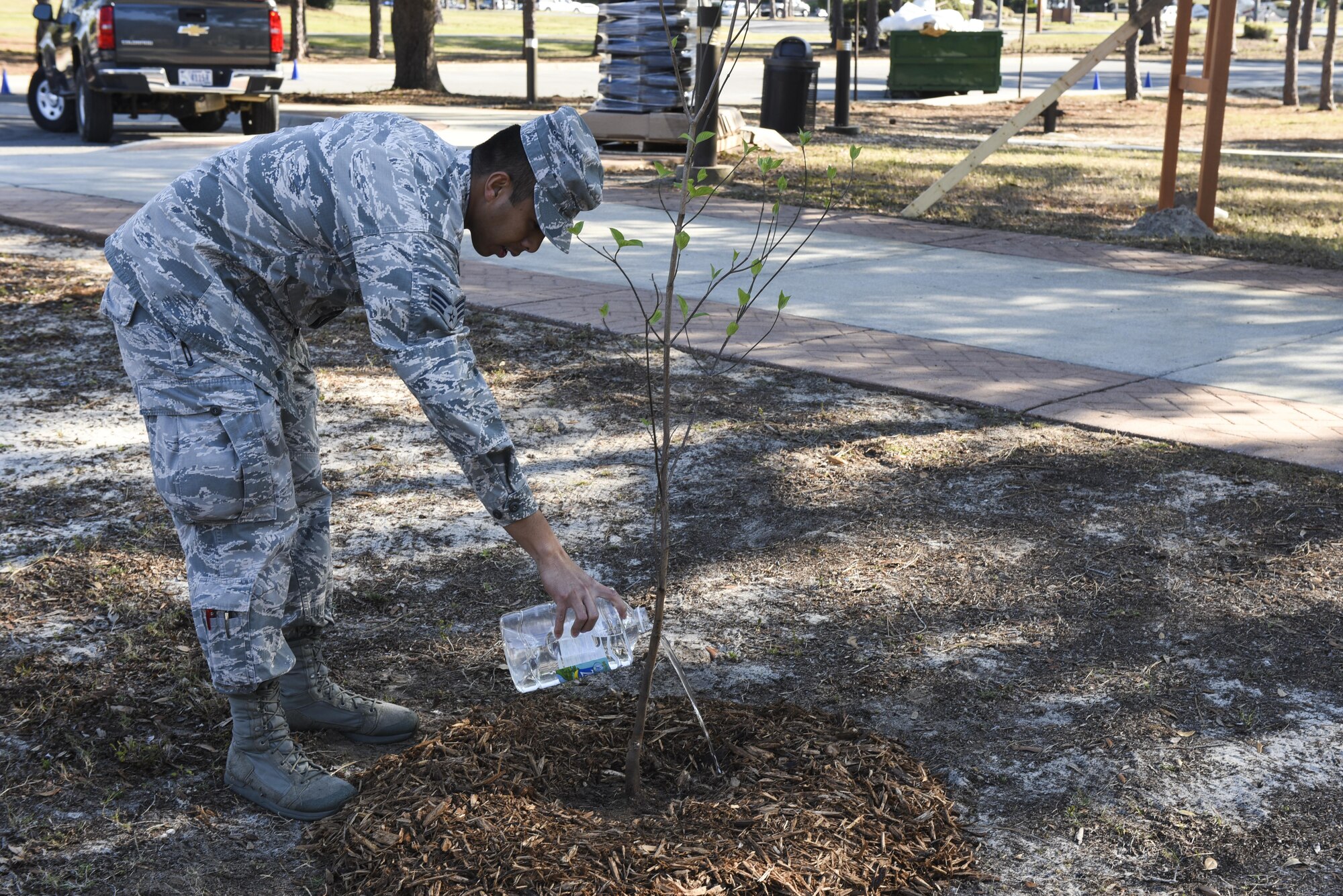 Senior Airman Giann Alessandro Recapuna, execution support with the 1st Special Operations Civil Engineer Squadron, waters a newly planted tree at the community park, Hurlburt Field, Fla., March 17, 2017. The 1st SOCES planted three new trees in honor of Arbor Day, observed on the fourth Friday of April. (U.S. Air Force photo by Senior Airman Jeff Parkinson)