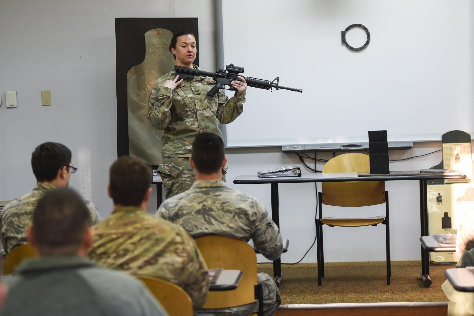 Staff Sgt. Elizabeth Marino, a Combat Arms Training and Maintenance instructor with the 1st Special Operations Security Forces Squadron, demonstrates how to properly hold an M4 rifle during a weapons qualification course at Hurlburt Field, Fla., March 16, 2017. Combat Arms Training and Maintenance instructors train and qualify Airmen on required weapons needed for deployments. (U.S. Air Force photo by Senior Airman Jeff Parkinson)