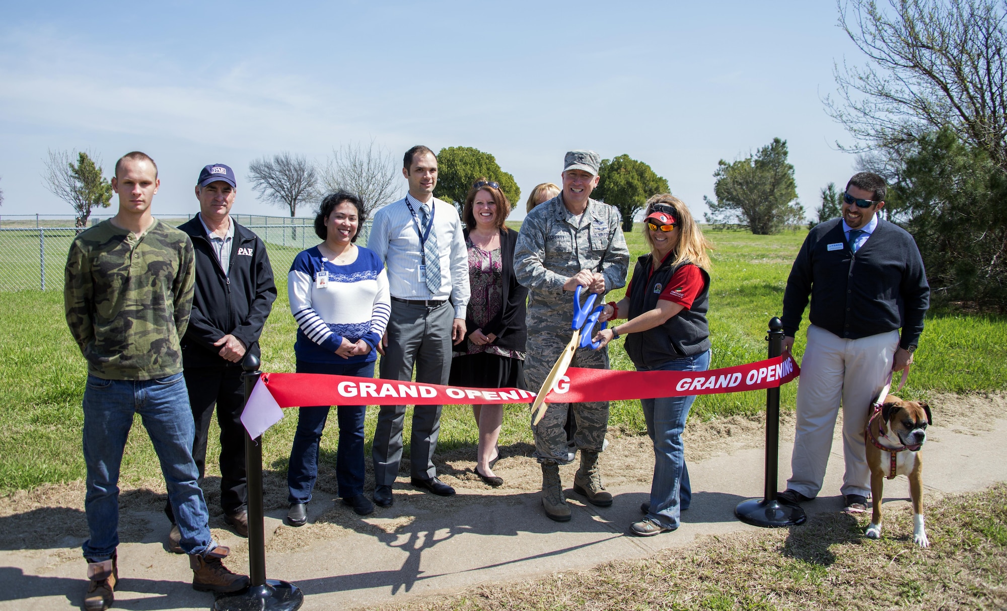 Brig. Gen. Patrick Doherty, 82nd Training Wing commander, along with Elizabeth Clements, Outdoor Recreation director, and other members of Team Sheppard, cut the ribbon during the grand reopening of the dog park at Wing Creek Park on Sheppard Air Force Base, Texas, March 15, 2017. (U.S. Air Force photo by Senior Airman Robert L. McIlrath/Released)