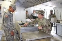 United States Army Reserve Command CW4 Kim Shiner checks the temperature of the meat before the 49th Multifunctional Medical Battalion Food Service Team serves lunch during the 2017 Philip A. Connelly Competition in Puerto Nuevo, Puerto Rico.