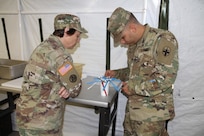49th Multifunctional Medical Battalion Food Operations Specialist, Jonathan Velez, calibrates a thermometer as United States Army Reserve Command ,CW4 Kim Shiner, evaluates his performance during the 2017 Philip A. Connelly Competition in Puerto Nuevo, Puerto Rico.