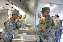 49th Multifunctional Medical Battalion Food Operations Specialist, Spc. Rosa Jimenez, serves Maj. Gen. William Lee, the Commanding General of the 3rd Medical Command Deployment Support, a meal prepared at the 2017 Philip A. Connelly Competition in Puerto Nuevo, Puerto Rico.