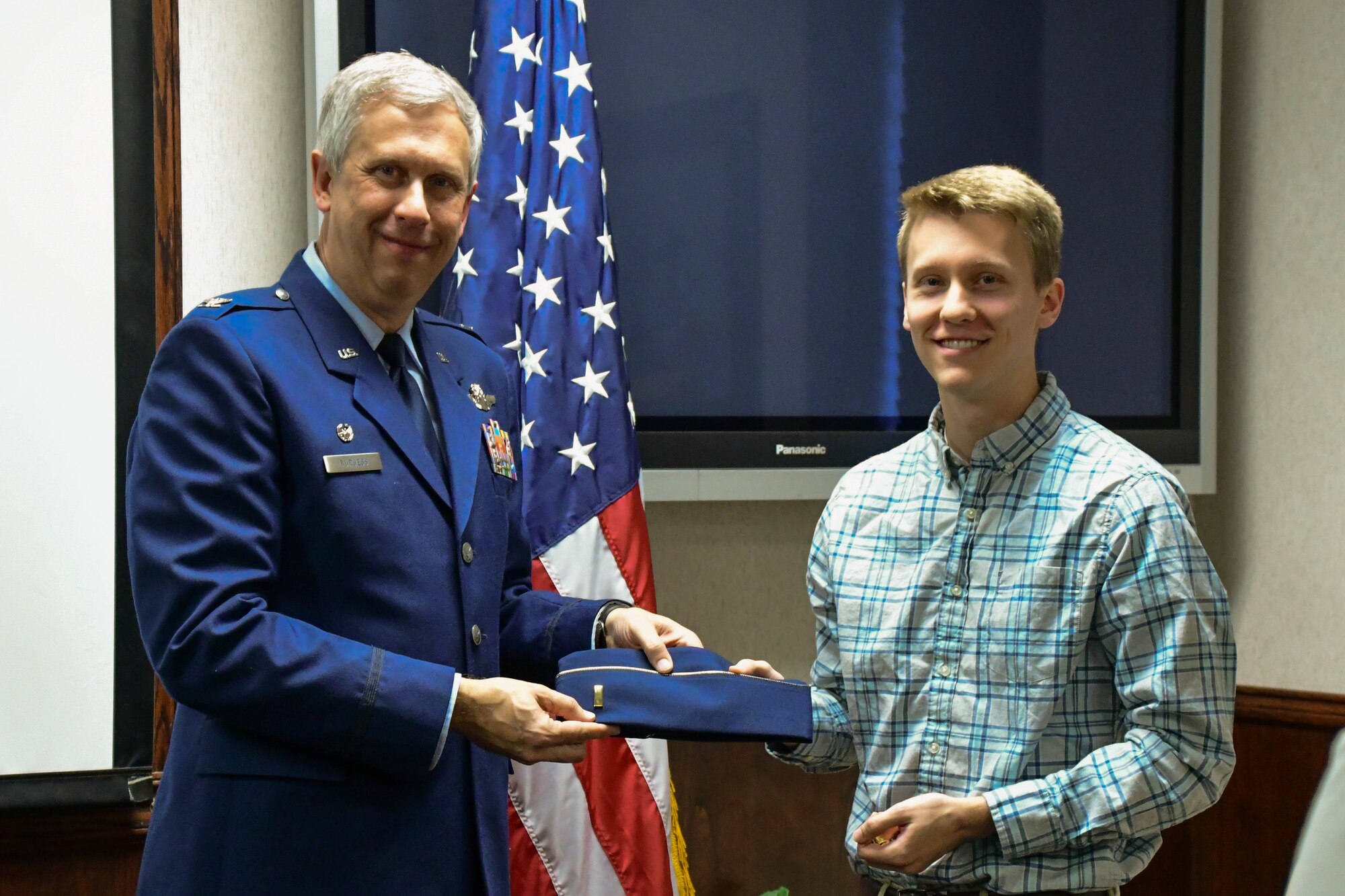 Col. Robert Burgess, commander of the 307th Operations Group, Barksdale Air Force Base, La., presents his son, Adam Burgess, second lieutenant ranks during a commissioning ceremony on Barksdale March 15, 2017. The rank Burgess presented were the ranks he was pinned on with during his graduation from the Air Force Academy. (U.S. Air Force photo by Master Sgt. Dachelle L. Melville/Released)