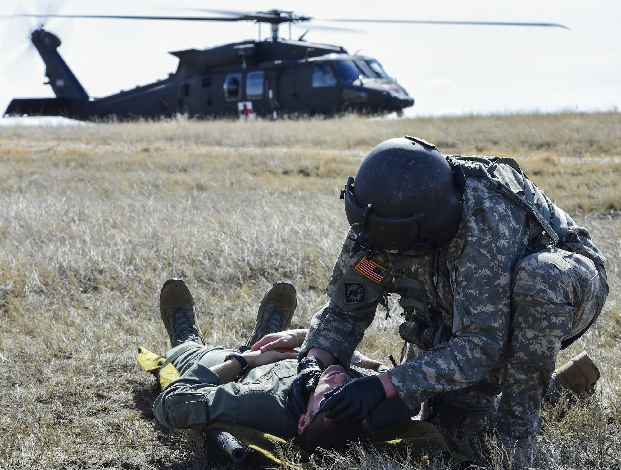 A U.S. Soldier with the South Dakota National Guard checks an Airman’s pulse during exercise Combat Raider at the Powder River Training Complex, March 15, 2017. Medical technicians with the SDNG participated in the exercise by providing a medical evacuation for Airmen acting as downed pilots. (U.S. Air Force photo by Airman 1st Class Randahl J. Jenson)