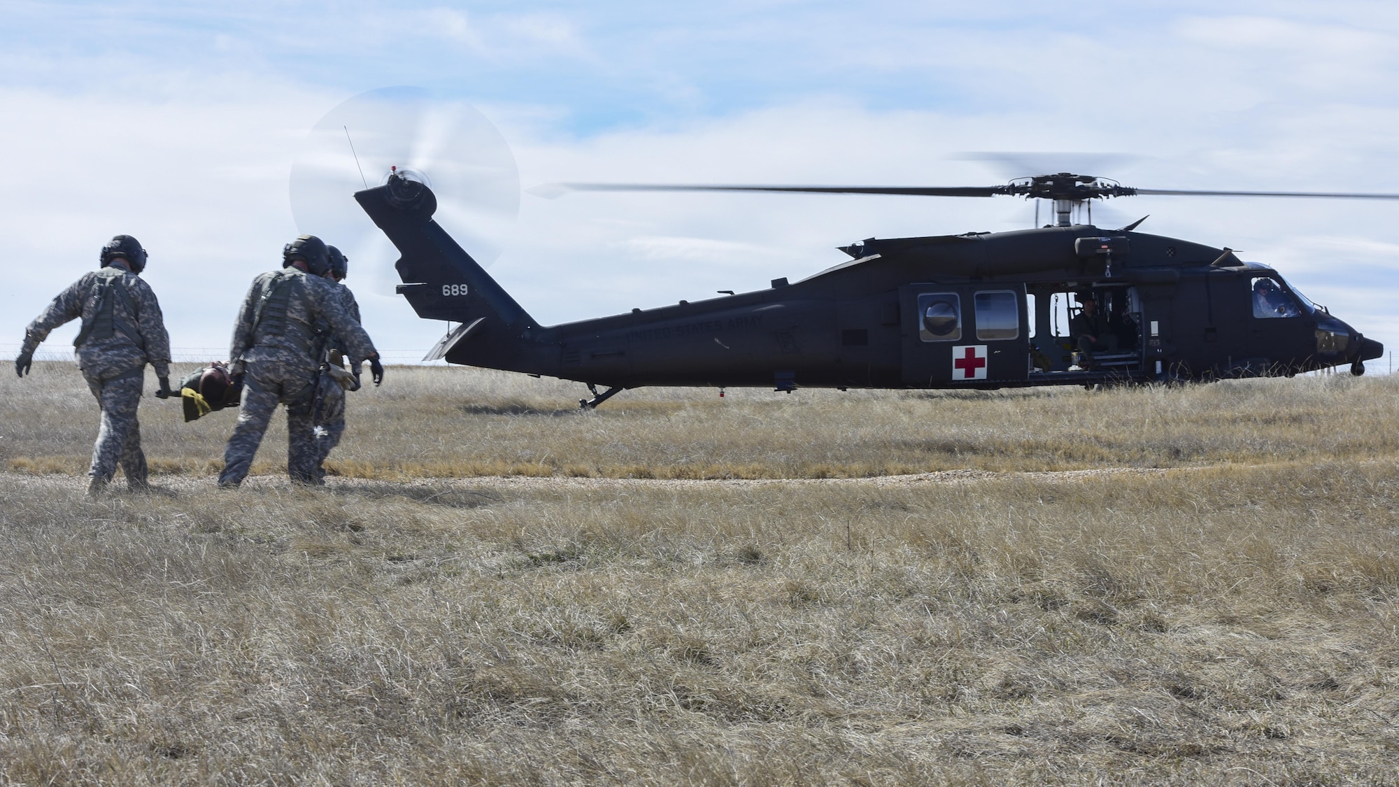 U.S. Soldiers with the South Dakota National Guard transport an Airman on a litter to an HH-60M Black Hawk helicopter during exercise Combat Raider at the Powder River Training Complex, March 15, 2017. Airmen and Soldiers participated in the joint-exercise, creating a realistic joint-operation environment. (U.S. Air Force photo by Airman 1st Class Randahl J. Jenson)