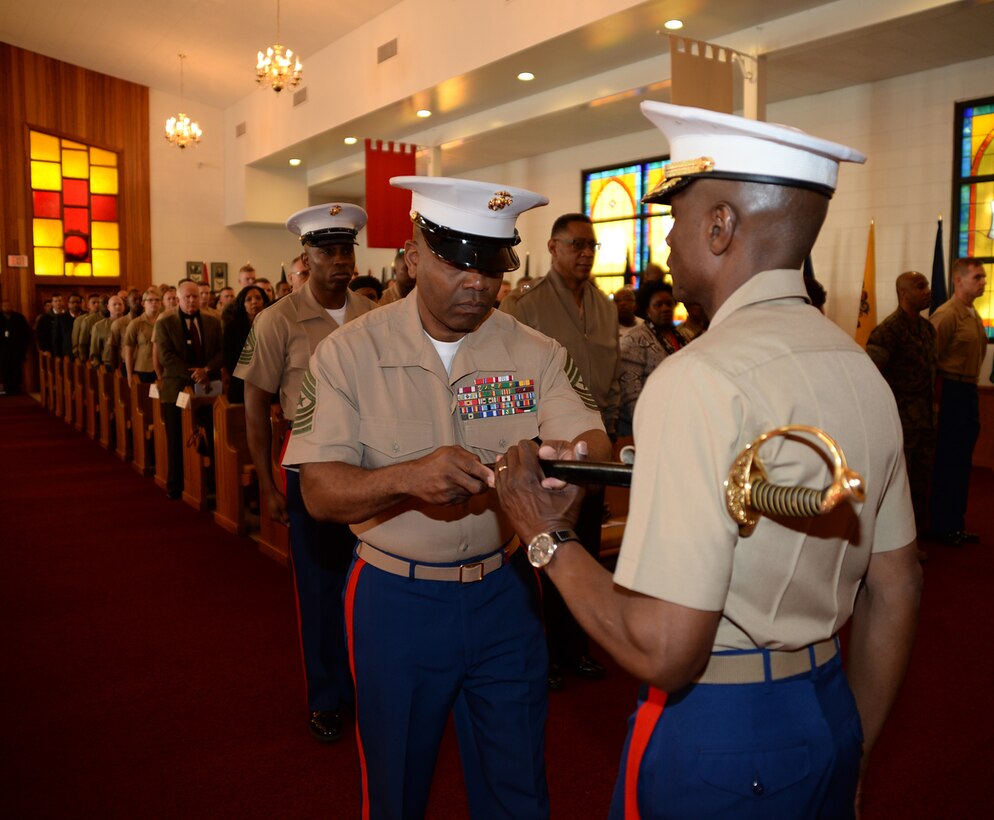 Sgt. Maj. Kenneth Agee, left, outgoing sergeant major, Marine Corps Logistics Base Albany, hands a noncommissioned officer's sword to Col. James C. Carroll III, commanding officer, MCLB Albany, which symbolizes the transfer of senior staff noncommissioned officer authority during a post and relief ceremony at the Chapel of the Good Shepherd, here, March 16. 