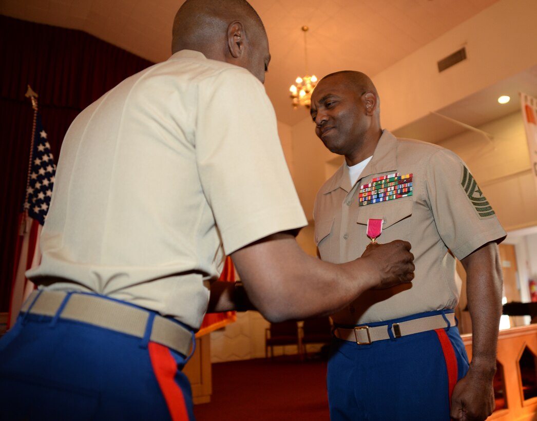 Sgt. Maj. Kenneth V. Agee, former sergeant major, Marine Corps Logistics Base Albany, receives a Legion of Merit from Col. James C. Carroll III, commanding officer, during a retirement ceremony at the Chapel of the Good Shepherd, here, March 16.