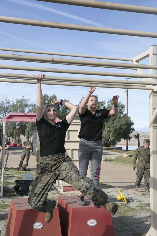 The wife of a Marine with 3rd Battalion, 4th Marines, 7th Marine Regiment, swings through the tactical monkey bars at the High Intensity Tactical Training obstacle course at Del Valle Field during the battalion’s Jane Wayne Day aboard Marine Corps Air Ground Combat Center, Twentynine Palms, Calif., March 8, 2017. (U.S. Marine Corps photo by Cpl. Julio McGraw)