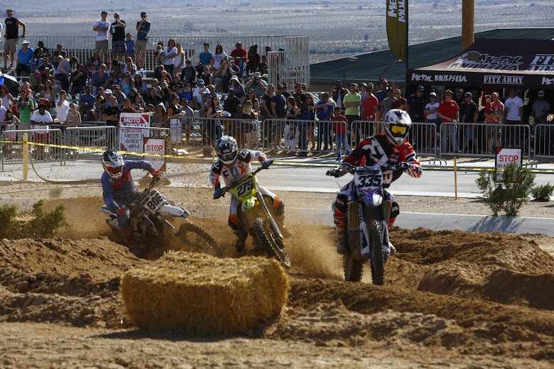 Three riders race against each other in the second race during the Motocross Jam Fest at 13th and Dunham aboard Marine Corps Air Ground Combat Center, Twentynine Palms, Calif., March 11, 2017. Marine Corps Community Services hosts the Motocross Jam Fest annually to provide Combat Center patrons with the opportunity to enjoy time out with their family and friends.  (U.S. Marine Corps photo by Lance Cpl. Natalia Cuevas)