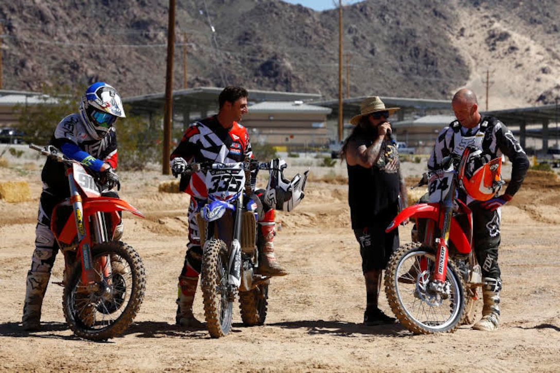 The Master of Ceremonies congratulates John Jelderda, Dennis Stapleton and Jeremy McCool, winners of the Motocross Jam Fest, at 13th and Dunham aboard Marine Corps Air Ground Combat Center, Twentynine Palms, Calif., March 11, 2017. Marine Corps Community Services hosts the Motocross Jam Fest annually to provide Combat Center patrons with the opportunity to enjoy time out with their family and friends.  (U.S. Marine Corps photo by Lance Cpl. Natalia Cuevas)