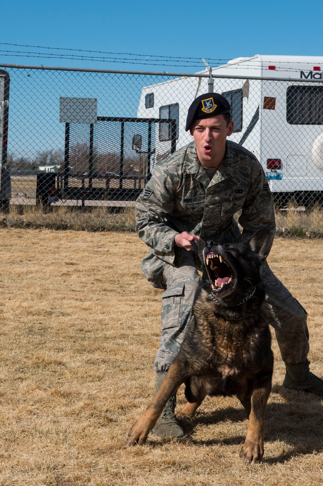 Senior Airman Michael Pigg, 90th Security Forces Squadron military working dog handler, holds back MWD, Oli, after an aggressor approaches during attack training at F.E. Warren Air Force Base, Wyo., March 16, 2017. Dog handlers attend a 55 day training in order to be certified to work with the dogs on base. (Air Force photo by Staff Sgt. Christopher Ruano) 