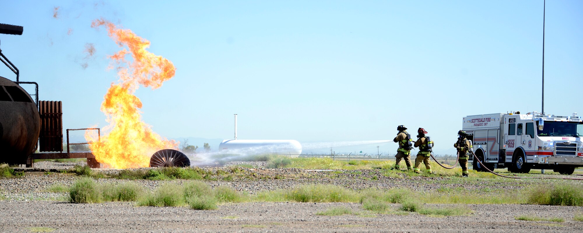 56th Civil Engineer Squadron firefighters and the Scottsdale Fire Department work together to put out a fire during a training exercise Mar. 16, 2017, at Luke Air Force Base, Ariz. The firefighters were training to respond to an aircraft fire. (U.S. Air Force photo by Senior Airman Devante Williams)  