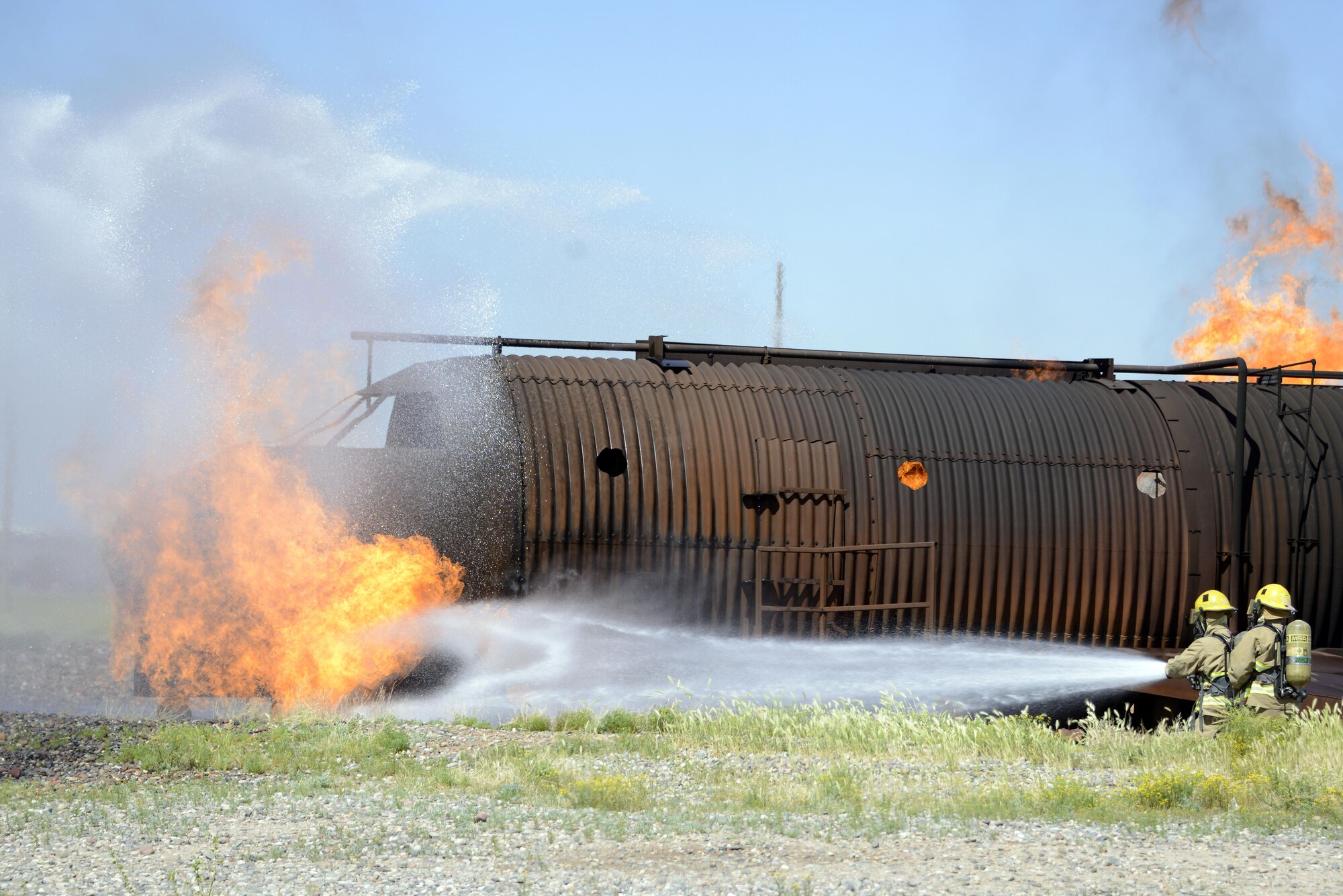 Members of the Scottsdale Fire Department spray water onto a fire during a joint training exercise Mar. 16, 2017, at Luke Air Force Base, Ariz. The objective of the exercise was to control the means of egress and evacuate victims while stabilizing the fire. (U.S. Air Force photo by Senior Airman Devante Williams)  