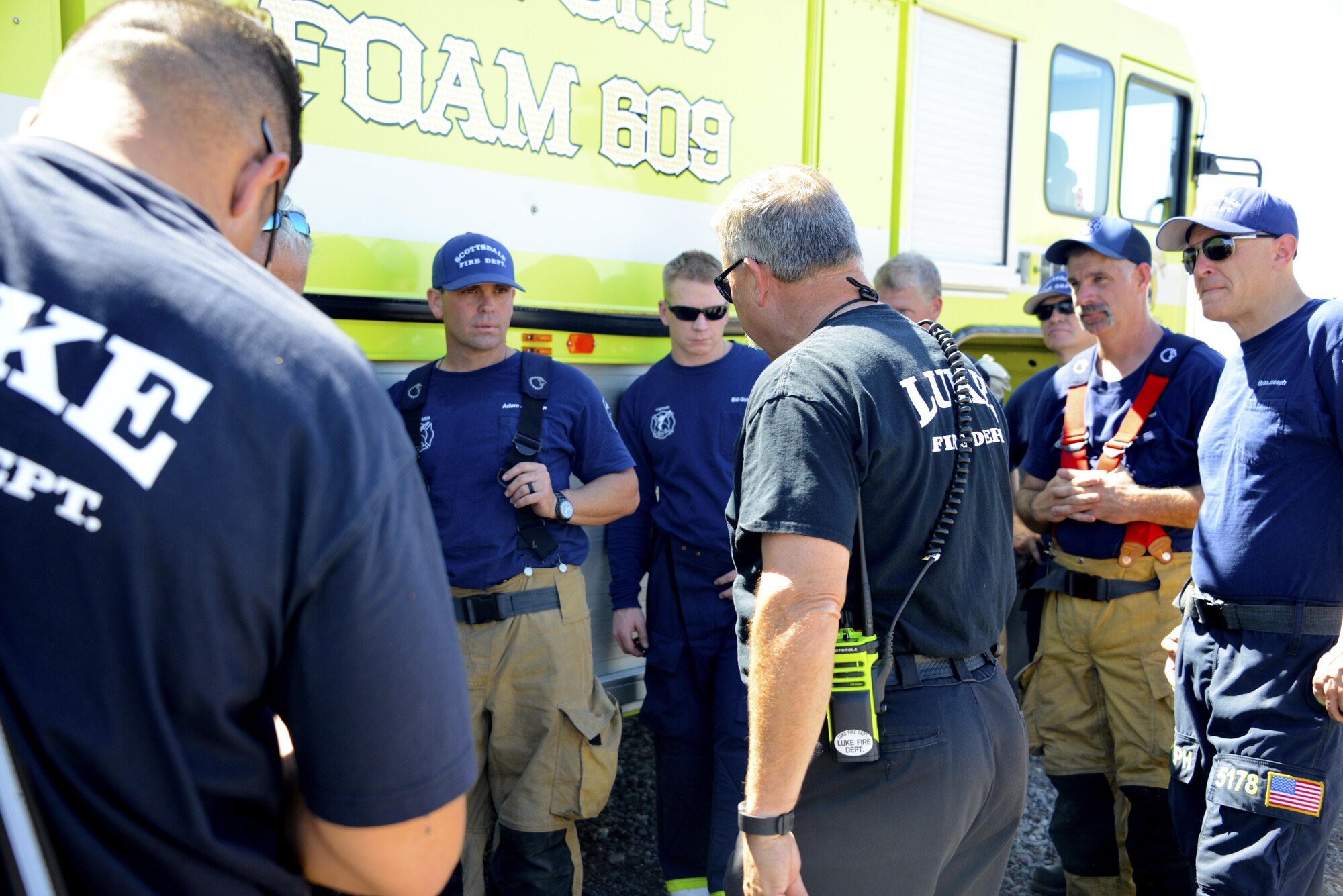 Steven Kinkade, 56th Civil Engineer Squadron assistant fire chief, speaks with Scottsdale firefighters after completing a training exercise Mar. 16, 2017 at Luke Air Force Base, Ariz. The objective of the exercise was to control the means of egress and evacuate victims while stabilizing the fire.(U.S. Air Force photo by Senior Airman Devante Williams)  