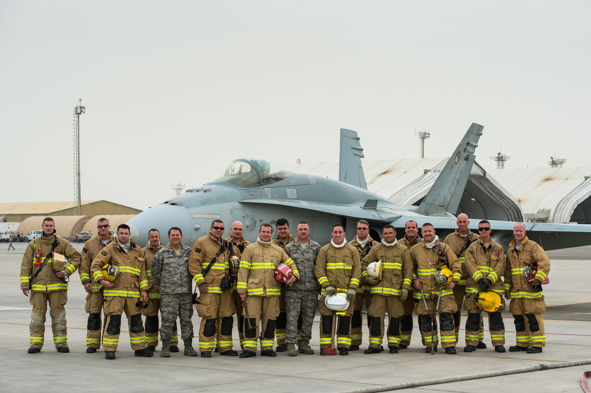 U.S. Air Force 380th Expeditionary Civil Engineer Squadron firefighters and Royal Australian Air Force firefighters pose for a group photo after completing a Coalition training exercise at an undisclosed location in Southwest Asia, March 16, 2017. USAF and RAAF firefighters have completed weekly exercises for nearly three months while supporting Operation Inherent Resolve. The training scenarios have developed critical firefighting fundamentals required during deployed day-to-day operations. (U.S. Air Force photo/Senior Airman Tyler Woodward)
