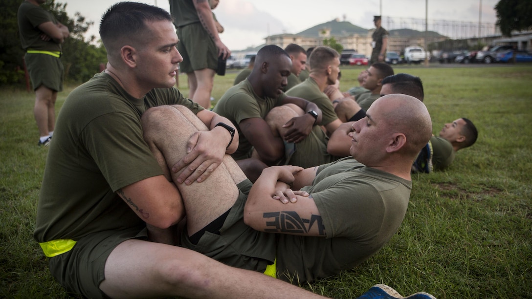 Marines with Headquarters Battalion conduct crunches during their Physical Fitness Test at Marine Corps Base Hawaii, March 14, 2017. The PFT is an evaluation conducted throughout the Marine Corps annually to assess the level of fitness. For more information on the PFT updates, utilize Marine Corps Bulletin 6100.