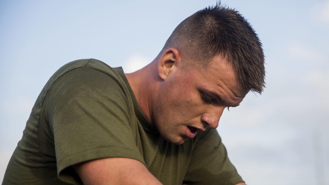 Lance Cpl. Sean Taylor, a radio operator with Headquarters Battalion, catches his breathe after finishing a 3-mile run during a Physical Fitness Test at Marine Corps Base Hawaii, March 14, 2017. The PFT is an evaluation conducted throughout the Marine Corps annually to assess the level of fitness. For more information on the PFT updates, utilize Marine Corps Bulletin 6100. 