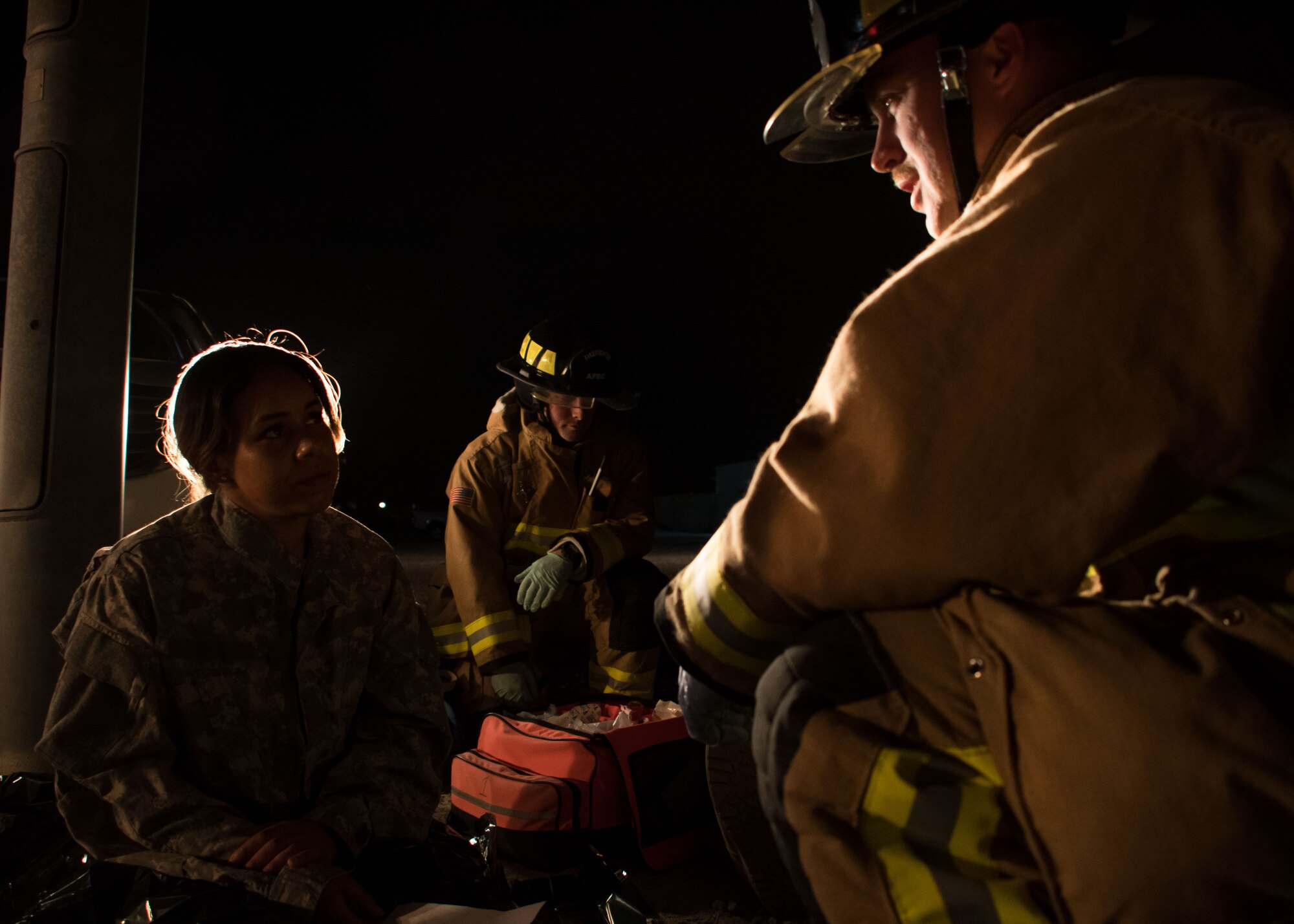 Senior Airman David Barker, a 386th Expeditionary Civil Engineer Squadron firefighter, center, and Senior Airman Phillip Osborne, a 386th ECES firefighter, right, talk with Senior Airman Jessica Mendoza, a 386th ECES firefighter, left, during a drill at an undisclosed location in Southwest Asia March 10, 2017. Mendoza played the role of a passenger who was confused and frantic after being involved in a car accident. (U.S. Air Force photo/Senior Airman Andrew Park)