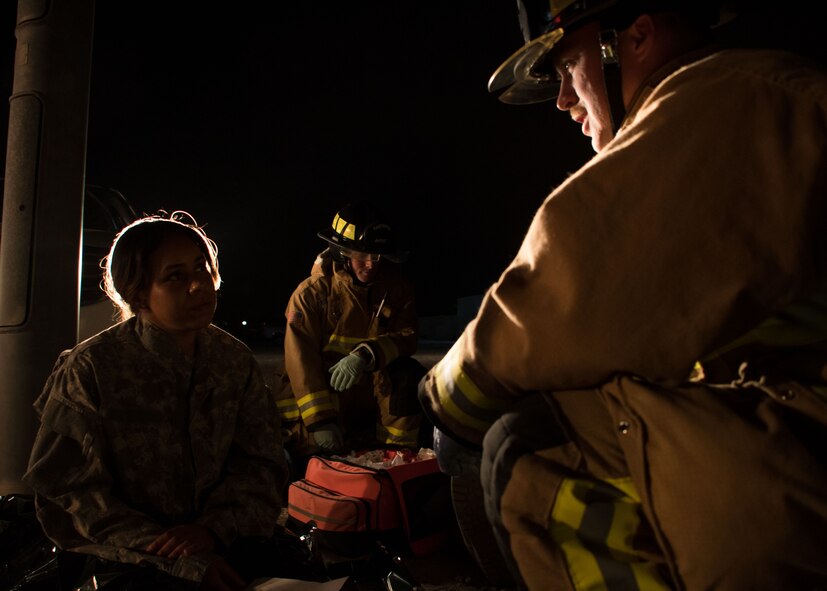 Senior Airman David Barker, a 386th Expeditionary Civil Engineer Squadron firefighter, center, and Senior Airman Phillip Osborne, a 386th ECES firefighter, right, talk with Senior Airman Jessica Mendoza, a 386th ECES firefighter, left, during a drill at an undisclosed location in Southwest Asia March 10, 2017. Mendoza played the role of a passenger who was confused and frantic after being involved in a car accident. (U.S. Air Force photo/Senior Airman Andrew Park)