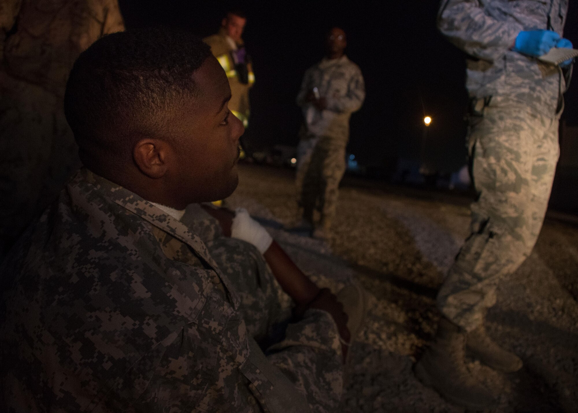 Senior Airman Kemien Brown, a 386th Expeditionary Civil Engineer Squadron firefighter, simulates waiting for medical transport during a drill at an undisclosed location in Southwest Asia March 10, 2017. Brown’s simulated injuries included minor cuts to his neck and arm, which were treated by firefighters and medics on the scene. (U.S. Air Force photo/Senior Airman Andrew Park)