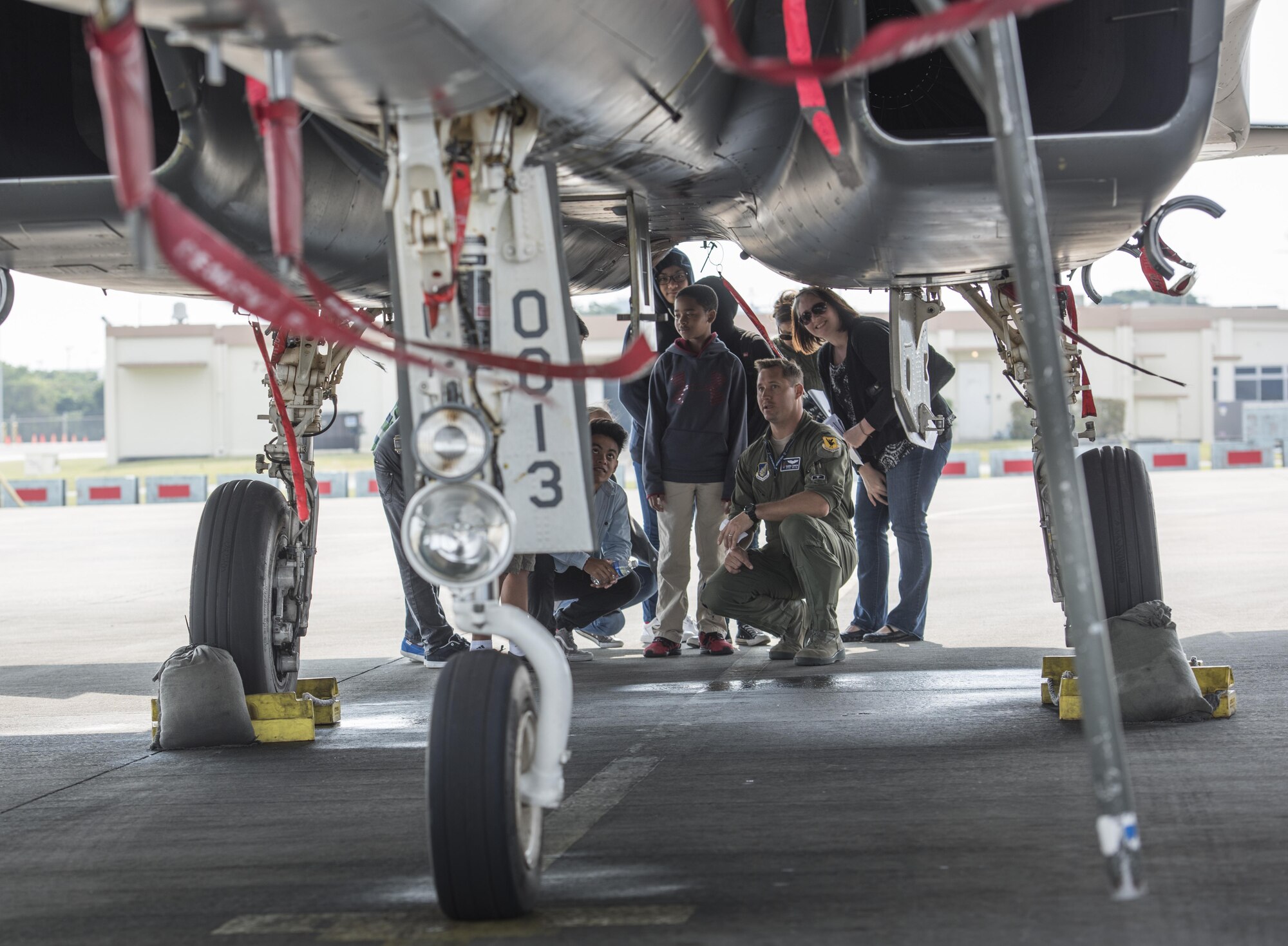 U.S. Air Force 1st Lt. Pete Gawor, 44th Fighter Squadron fighter pilot, shows Kadena Middle School students the underbelly of an F-15C Eagle, March 3, 2017, at Kadena Air Base, Japan. Kadena Middle School students learned about the F-15C Eagle during a Science, Technology, Engineering and Math tour. (U.S. Air Force photo by Senior Airman Omari Bernard)