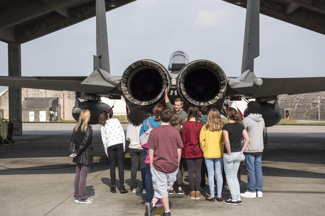 U.S. Air Force 1st Lt. Brock McGehee, 44th Fighter Squadron F-15 Eagle pilot, shows Kadena Middle School students the engine exhausts of an F-15C Eagle, March 3, 2017, at Kadena Air Base, Japan. Kadena Middle School students toured the 18th Operations Squadron as part of a Science, Technology, Engineering and Math initiative. (U.S. Air Force photo by Senior Airman Omari Bernard)