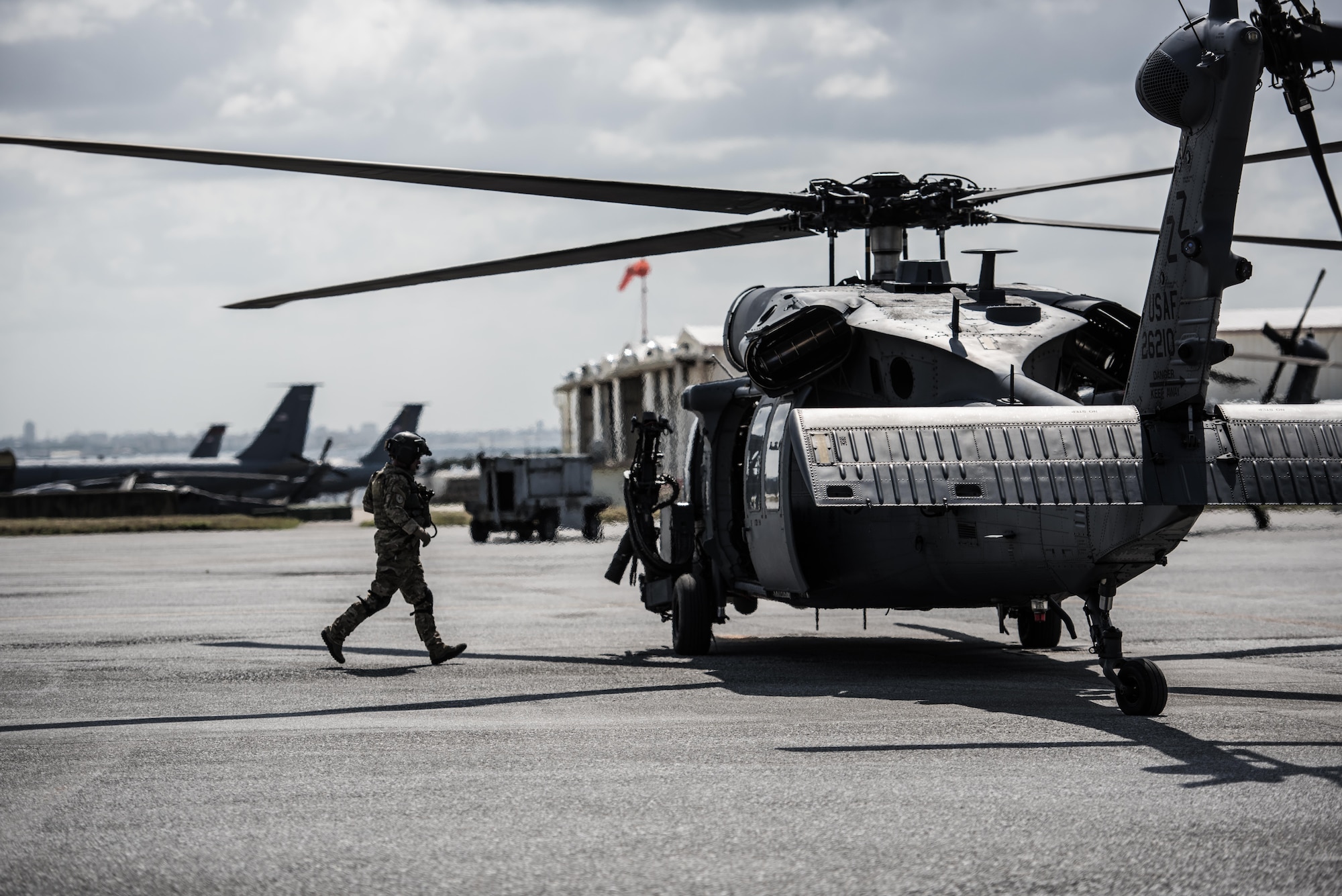 An Airmen from the 33rd Rescue Squadron dashes back to a running HH-60 Pavehawk during hot-refueling during routine training on the flightline March 7, 2017, at Kadena Air Base, Japan. Members of the 33rd Rescue Squadron from Kadena AB train to provide support for combat rescue and disaster relief. (U.S. Air Force photo by Senior Airman Omari Bernard)