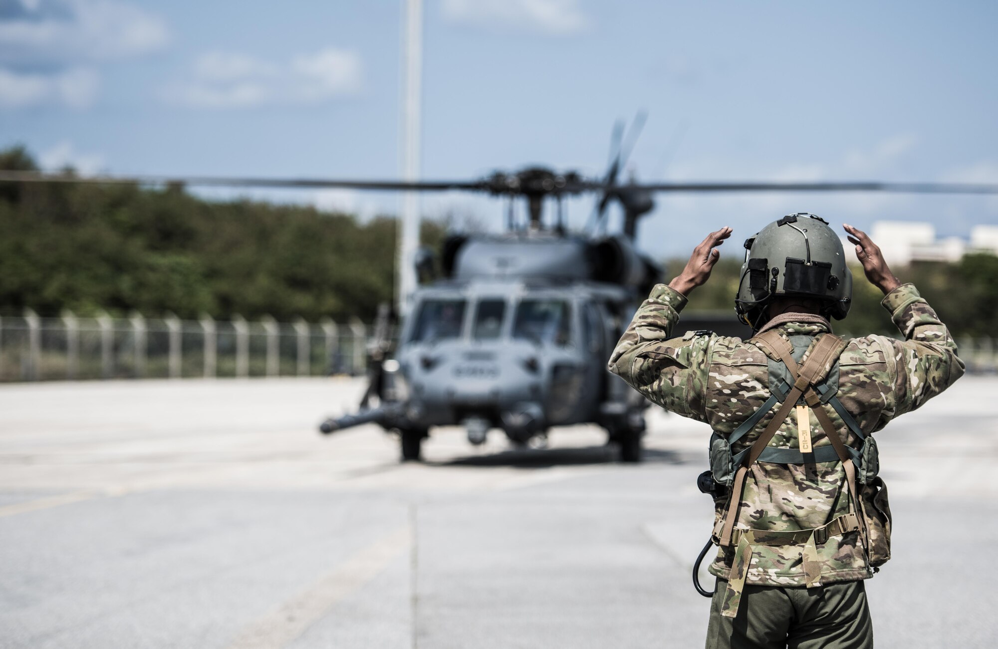 An HH-60 Pavehawk crewmember from the 33rd Rescue Squadron directs a helicopter onto a refueling station March 7, 2017, at Kadena Air Base, Japan. Airmen from the 33rd RQS train night and day to provide support in disaster and rescue operations. (U.S. Air Force photo by Senior Airman Omari Bernard)