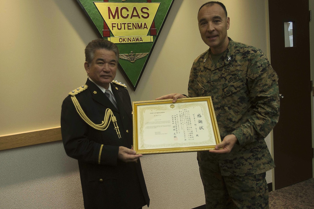 Ginowan Police Chief Motoki Haneji, left, awards Col. Peter N. Lee with a letter of authorization Feb. 28 on Marine Corps Air Station Futenma, Okinawa, Japan. Lee was recognized by Haneji for the significant mutual support and cooperation between MCAS Futenma and the Ginowan City Police Department during the chief’s command tenure. Haneji is retiring from his duties as chief of the Ginowan Police Department. "Since the chief has arrived at Ginowan, we've had a great relationship with him, and because of him we've really enhanced the partnership between the station and the city,” said Lee, the commanding officer of MCAS Futenma. "Because of him we will continue to strive to be the best partners we can be."