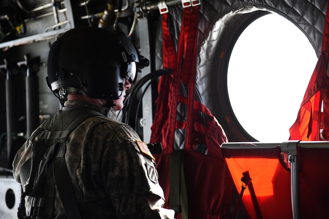 A South Carolina Army National Guard crew chief looks out a window before a CH-47F Chinook helicopter lands while conducting high-altitude flight operations near Vail, Colo., March 10, 2017. Army National Guard photo by Staff Sgt. Roberto Di Giovine