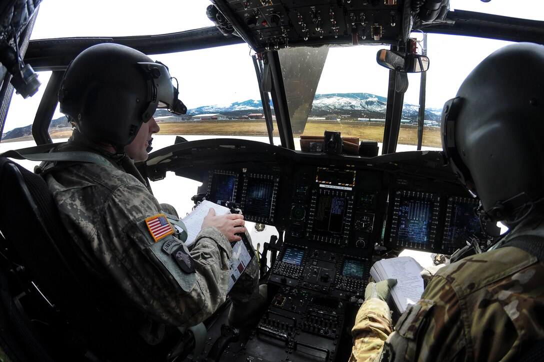 South Carolina Army National Guard pilots review their flight manuals in the cockpit of their CH-47F Chinook helicopter before conducting high-altitude flight operations near Vail, Colo., March 10, 2017. Army National Guard photo by Staff Sgt. Roberto Di Giovine