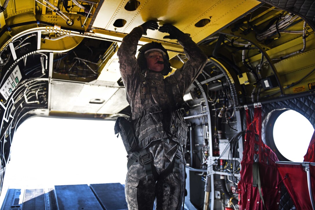 A South Carolina Army National Guard crew chief performs pre-flight checks in the back of a CH-47F Chinook helicopter before conducting high-altitude flight operations near Vail, Colo., March 10, 2017. Army National Guard photo by Staff Sgt. Roberto Di Giovine