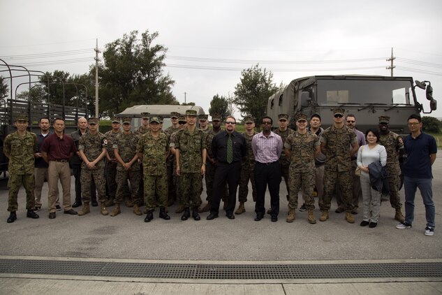 Camp Kinser Camp Operations staff pose for a photo with Japan Ground Self-Defense Force members March 17 on Camp Naha, Okinawa, Japan. This is the first time a Marine Corps Installations Pacific Camp Operations office has visited a Japan Ground Self-Defense Force base. The visit included a lunch with JGSDF members and a museum and base tour. (U.S. Marine Corps photo by Cpl. Jessica Collins)