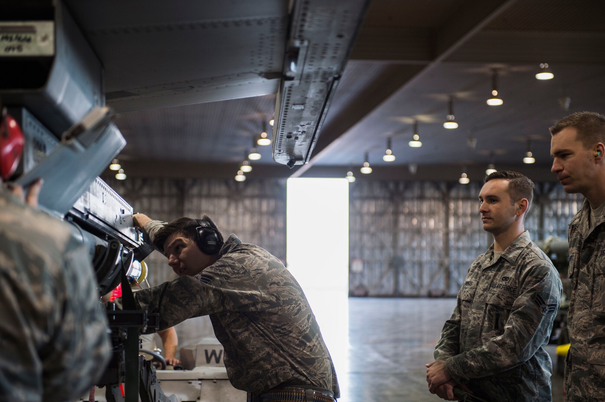 U.S. Air Force Staff Sgt. Daniel Garrison, weapons load crew team chief, left, slide an AIM-9 sidewinder on a LAU-129 rail, while Senior Airman Jacob D. Jennings, center, and Senior Airman Aaron Paul Colbert, right, both 35th Maintenance Group weapons standardization evaluators, observe him at Misawa Air Base, Japan, Feb. 28, 2017. Misawa commits to enhancing stability in the Indo-Asia-Pacific region by promoting security, cooperation, deterring aggression, with continued partnership, presence and military readiness. (U.S. Air Force photo by Tech. Sgt. Araceli Alarcon)