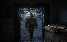 Firefighters from the 35th Civil Engineer Squadron, enter a condemned building to start a controlled burn at Misawa Air Base, Japan, March 15, 2017. Rather than bulldoze, the firefighters incinerated the Ninja Zone, formally a civil engineer work-center, to save demolition costs. The firefighters trained on their forcible entry techniques and learned more about fire behavior. They train to meet both local and global missions. (U.S. Air Force photo by Staff Sgt. Melanie A. Hutto)