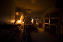A 35th Civil Engineer Squadron firefighter adds starter fluid to the wood pallets in a condemned building at Misawa Air Base, Japan, March 15, 2017. The wooden structure was burned down to save on demolition cost. The facility took approximately two hours to burn from the initial ignition to total destruction. It was still actively burning (smoldering) for an additional 12 to 18 hours after. The 35th Fighter Wing firefighters train to meet both local and global missions. (U.S. Air Force photo by Staff Sgt. Melanie A. Hutto)