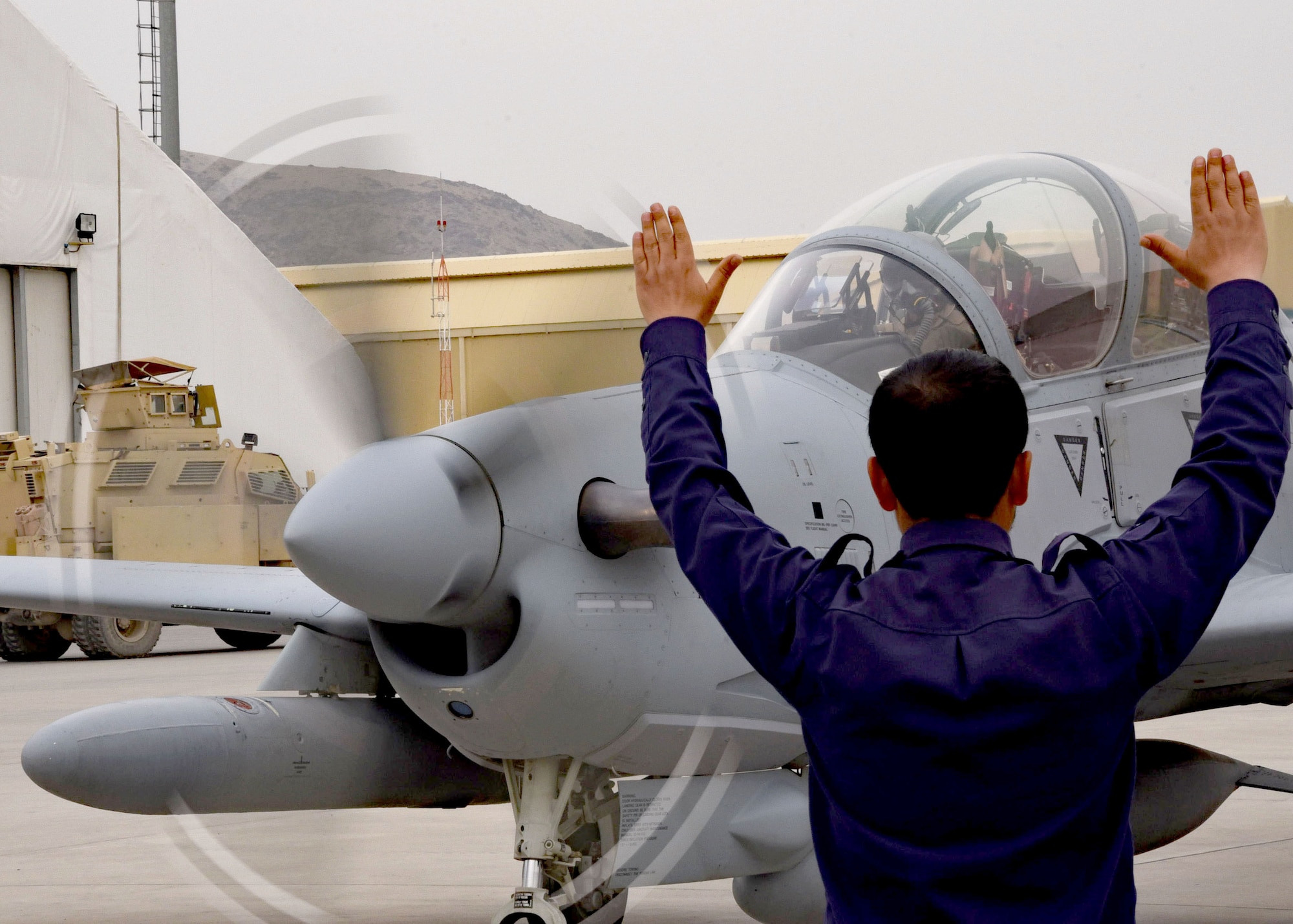 An Afghan Air Force crew chief marshals in one of four A-29 Super Tucano light-attack aircraft arriving for duty at Kabul Air Wing, Kabul, Afghanistan, March 20, 2017. The A-29s will be used by the Afghan Air Force for close-air attack, air interdiction, escort and armed reconnaissance. These latest arrivals, which traveled from Moody Air Force Base, Ga., bring the AAF A-29 inventory from eight to 12 aircraft in country. (U.S. Air Force photo by Tech. Sgt. Veronica Pierce)