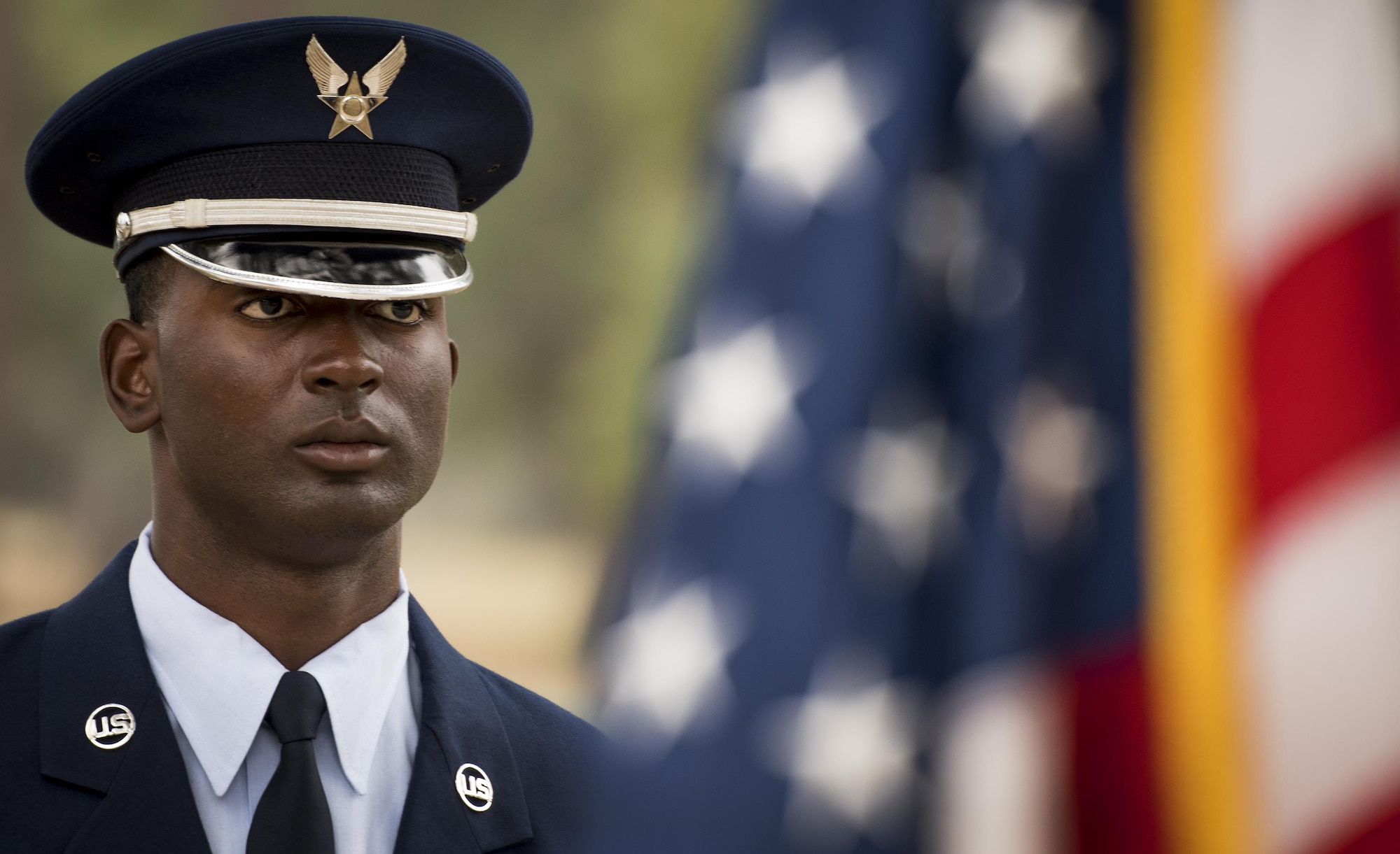 Kadeem Bell, 96th Force Support Squadron, stands by an American flag prior to the Honor Guard graduation ceremony at Eglin Air Force Base, Fla., March 1.  Approximately 12 new Airmen graduated from the 120-plus-hour course. The graduation performance includes flag detail, rifle volley, pall bearers and bugler for friends, family and unit commanders. (U.S. Air Force photo/Samuel King Jr.)
