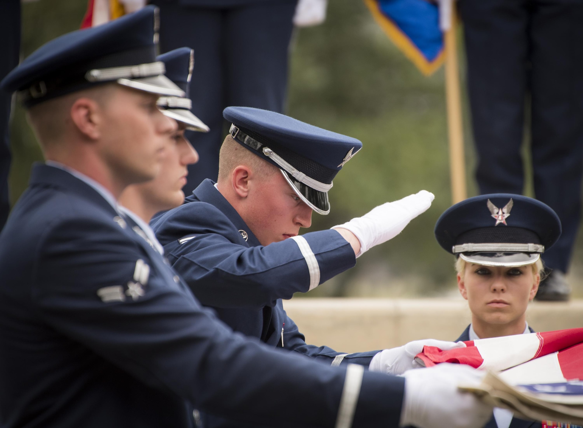 An Honor Guard Airman brings his hand down to smooth out the flag during the flag-folding portion at the unit’s graduation ceremony at Eglin Air Force Base, Fla., March 1.  Approximately 12 new Airmen graduated from the 120-plus-hour course. The graduation performance includes flag detail, rifle volley, pall bearers and bugler for friends, family and unit commanders. (U.S. Air Force photo/Samuel King Jr.)