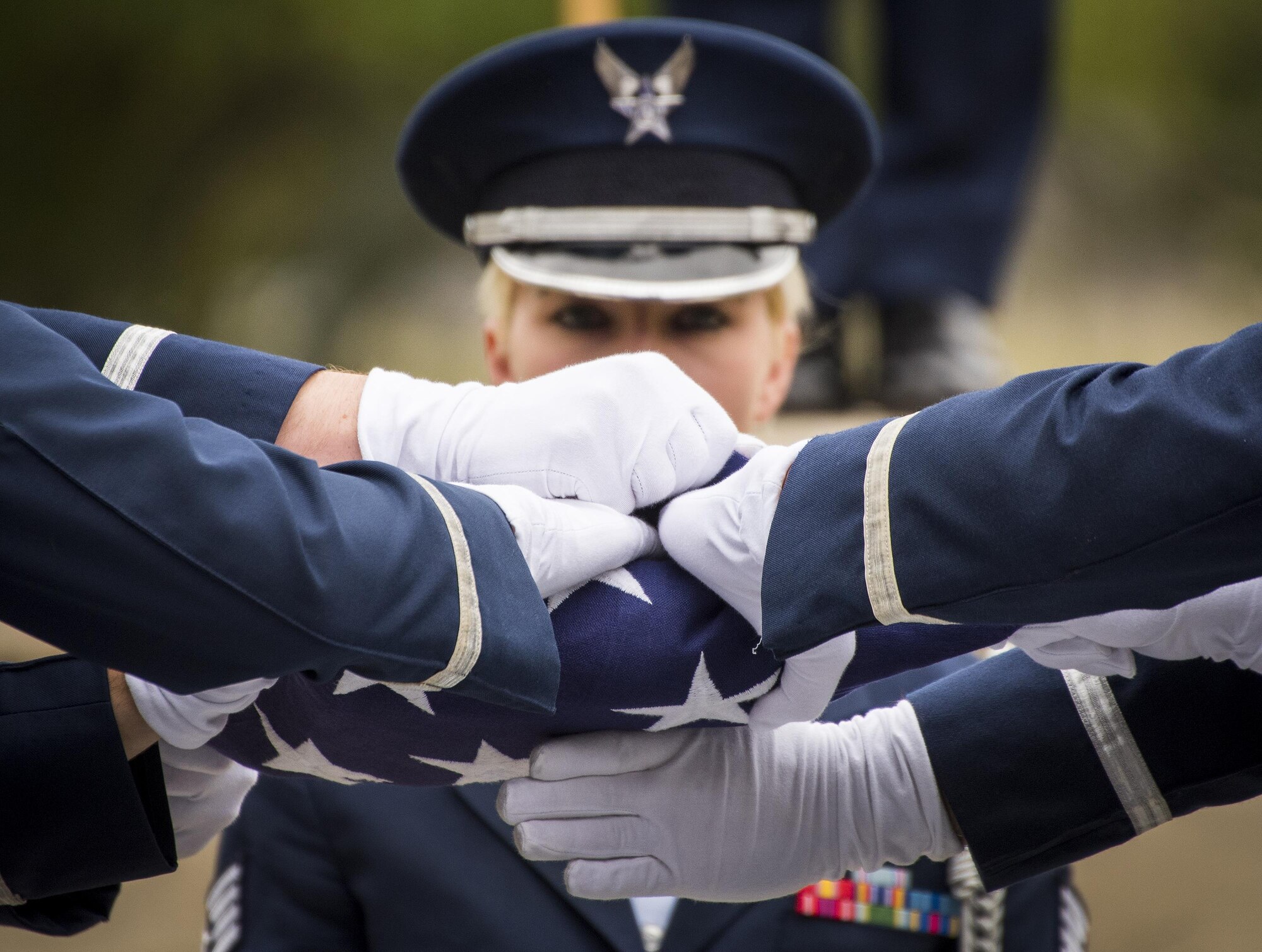 Honor Guard Airmen tighten and tuck in the rest of the American flag at the conclusion of the flag-folding portion at the unit’s graduation ceremony at Eglin Air Force Base, Fla., March 1.  Approximately 12 new Airmen graduated from the 120-plus-hour course. The graduation performance includes flag detail, rifle volley, pall bearers and bugler for friends, family and unit commanders. (U.S. Air Force photo/Samuel King Jr.)